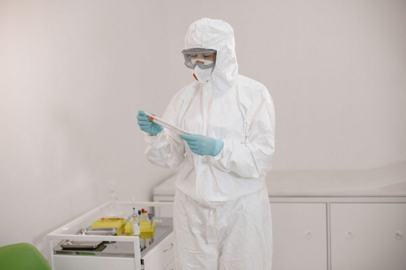 Técnico aplicando tratamento de controle de pragas em sala de espera de clínica