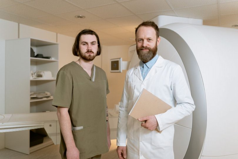Técnico com EPI aplicando controle de pragas no corredor de uma clínica
