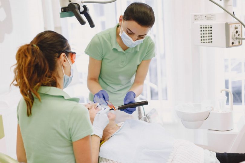 Técnico com equipamento de controle de pragas aplicando tratamento em sala de clínica