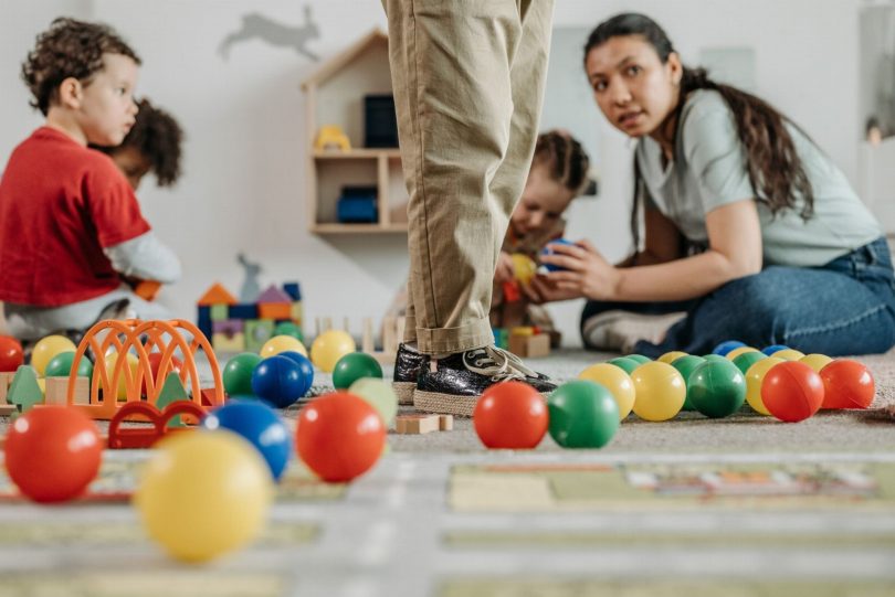 Técnico realizando dedetização segura em sala de creche com brinquedos afastados