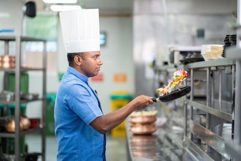 Técnico realizando inspeção de dedetização em cozinha de restaurante comercial em Belo Horizonte