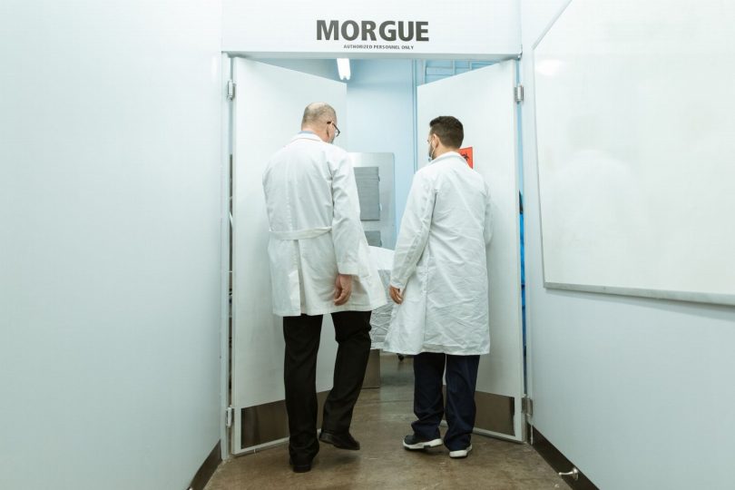 Técnico aplicando produto de sanitização em corredor de hospital